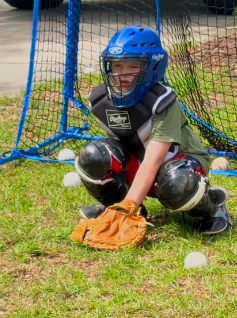 Cash standing in catcher's gear with his mitt